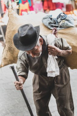 Sokakta dövmesi olan şapkalı bir adam.