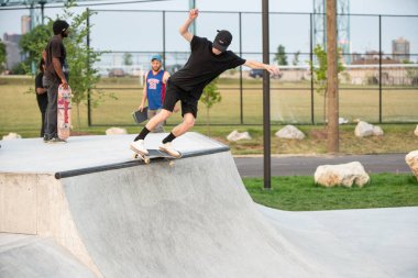 Detroit, Michigan, ABD - 08.07.2019: Detroit şehir kaykay parkında güneşli bir günde patenciler numaralarını prova ediyorlar.