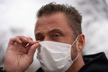 Coronavirus sırasında maske takan beyaz bir adam.