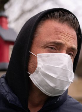 Coronavirus sırasında maske takan beyaz bir adam.