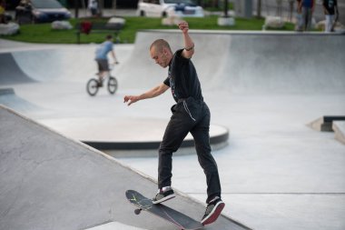 Detroit, Michigan, ABD - 08.07.2019: Detroit şehir kaykay parkında güneşli bir günde patenciler numaralarını prova ediyorlar.