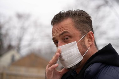 Coronavirus sırasında maske takan beyaz bir adam.