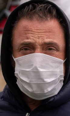 Coronavirus sırasında maske takan beyaz bir adam.