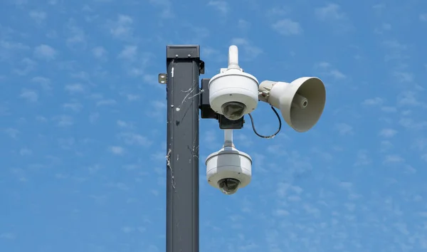 security cameras are mounted high to watch the activity nearby