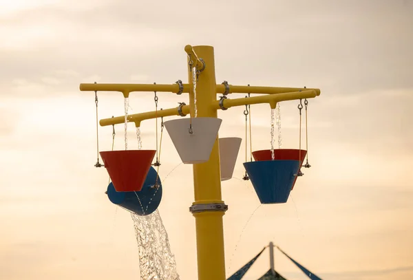 water buckets pour out at a water park giving relief on a hot day of summer time