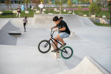 Detroit, Michigan, ABD - 10.07.2019: Patenciler ve motosikletçiler Detroit 'teki kaykay parkında gün batımında numara yapıyorlar