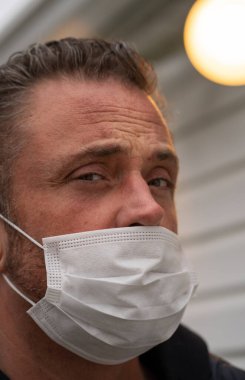 Coronavirus sırasında maske takan beyaz bir adam.