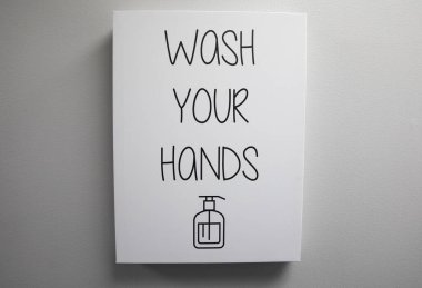 Tabelada ellerini yıkaman gerektiği yazıyor.