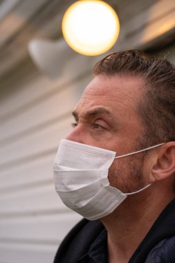 Coronavirus sırasında maske takan beyaz bir adam.