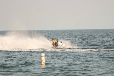 Dalgacılar ve su araçları gölde numaralar yapıyor..