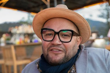 Şapkalı ve güneş gözlüklü yakışıklı bir adamın portresi.