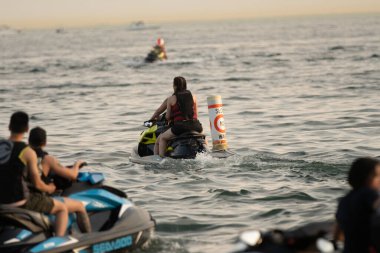 Kişisel su araçları güneşli bir günde Metro Parkı 'nda eğleniyor ve numaralar yapıyor.