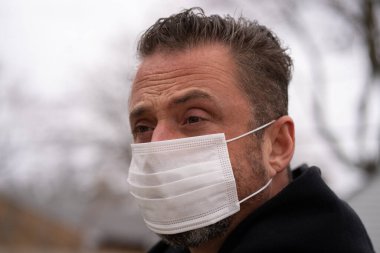 Coronavirus sırasında maske takan beyaz bir adam.
