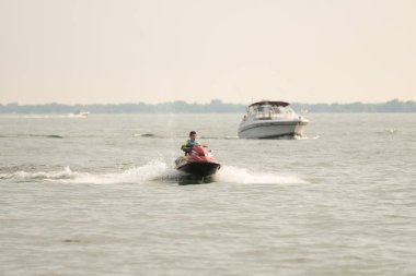 Kişisel su araçları güneşli bir günde Metro Parkı 'nda eğleniyor ve numaralar yapıyor.
