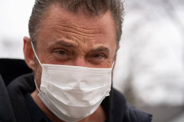 Coronavirus sırasında maske takan beyaz bir adam.