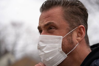 Coronavirus sırasında maske takan beyaz bir adam.