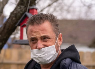 Coronavirus sırasında maske takan beyaz bir adam.