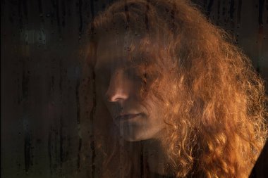 Stüdyoda poz veren uzun saçlı genç adam.