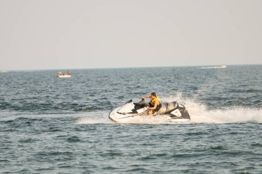 Dalgacılar ve su araçları gölde numaralar yapıyor..