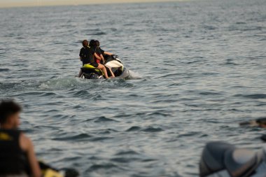 Kişisel su araçları güneşli bir günde Metro Parkı 'nda eğleniyor ve numaralar yapıyor.