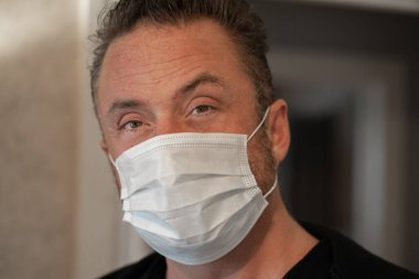Mikroplardan korunmak için koruyucu maske takan bir adam.