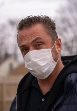 Coronavirus sırasında maske takan beyaz bir adam.
