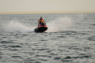 Kişisel su araçları güneşli bir günde Metro Parkı 'nda eğleniyor ve numaralar yapıyor.