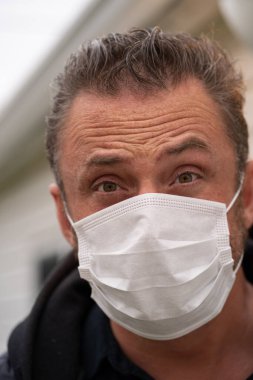 Coronavirus sırasında maske takan beyaz bir adam.
