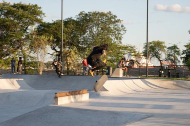 Detroit, Michigan, ABD - 08.09.2019: Patenciler gün batımında paten parkında numaralar yapıyor