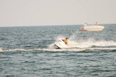 Dalgacılar ve su araçları gölde numaralar yapıyor..
