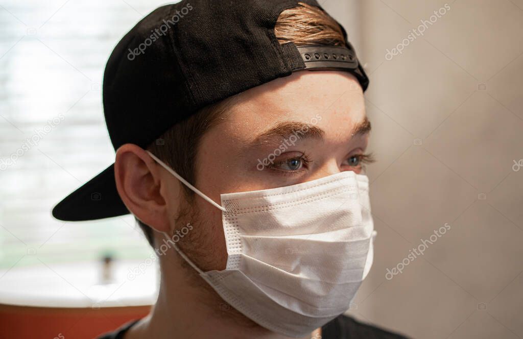 Teenager boy wearing a protective breathing mask from virus COVID-19.