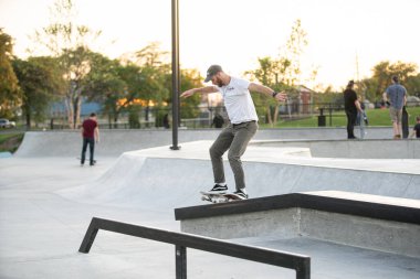 Detroit, Michigan, ABD - 10.07.2019: Patenciler ve motosikletçiler Detroit 'teki kaykay parkında gün batımında numara yapıyorlar