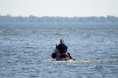 Denizde kayığa binen adam.