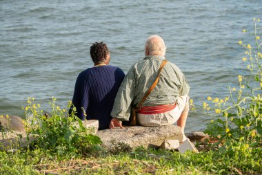 Karışık ırk çiftleri sahilde baş başa vakit geçiriyorlar.