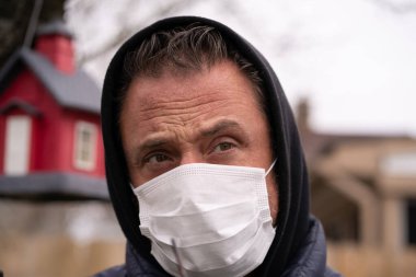 Coronavirus sırasında maske takan beyaz bir adam.