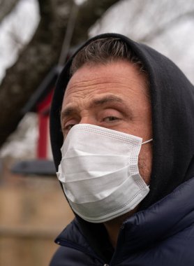 Coronavirus sırasında maske takan beyaz bir adam.