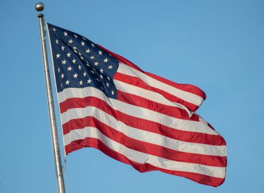 Güneşli bir günde rüzgarda dalgalanan Amerikan bayrağı