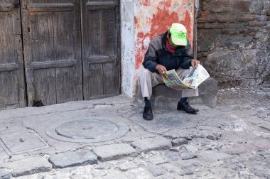Kasklı ve siyah şapkalı bir adam.