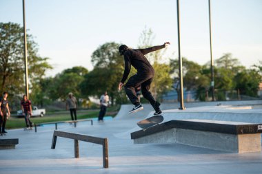 Detroit, Michigan, ABD - 07.14.2019: Patenciler gün batımında Detroit 'teki kaykay parkında numaralarını çalışıyorlar