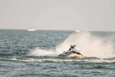 Dalgacılar ve su araçları gölde numaralar yapıyor..