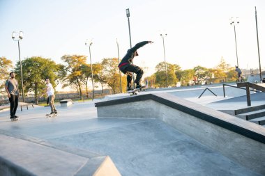 Detroit, Michigan, ABD - 10.20.2019: Detroit 'te gün batımında kaykay parkında antrenman yapan patenciler ve motorcular