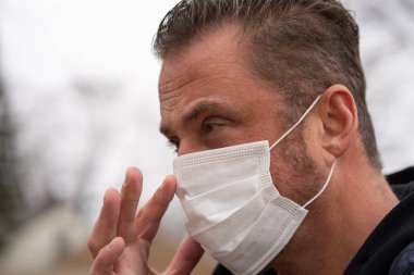 Coronavirus sırasında maske takan beyaz bir adam.
