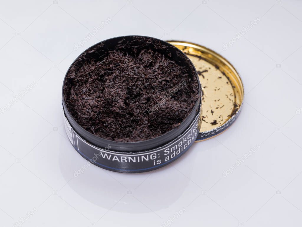 black cosmetic powder in a glass jar on white background