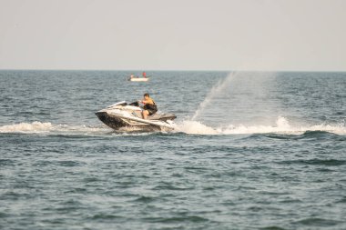 Dalgacılar ve su araçları gölde numaralar yapıyor..