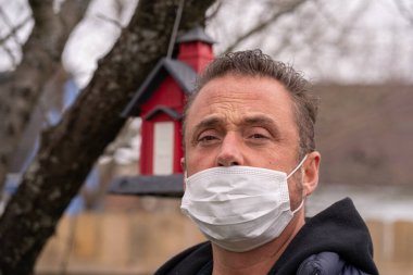 Coronavirus sırasında maske takan beyaz bir adam.