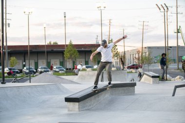 Detroit, Michigan, ABD - 10.07.2019: Patenciler ve motosikletçiler Detroit 'teki kaykay parkında gün batımında numara yapıyorlar