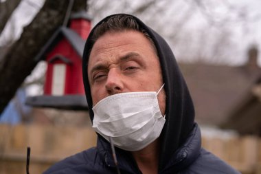 Coronavirus sırasında maske takan beyaz bir adam.