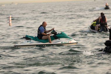 Kişisel su araçları güneşli bir günde Metro Parkı 'nda eğleniyor ve numaralar yapıyor.
