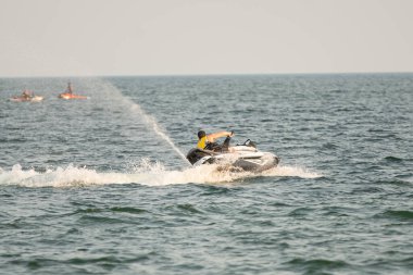 Dalgacılar ve su araçları gölde numaralar yapıyor..