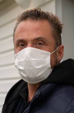 Coronavirus sırasında maske takan beyaz bir adam.